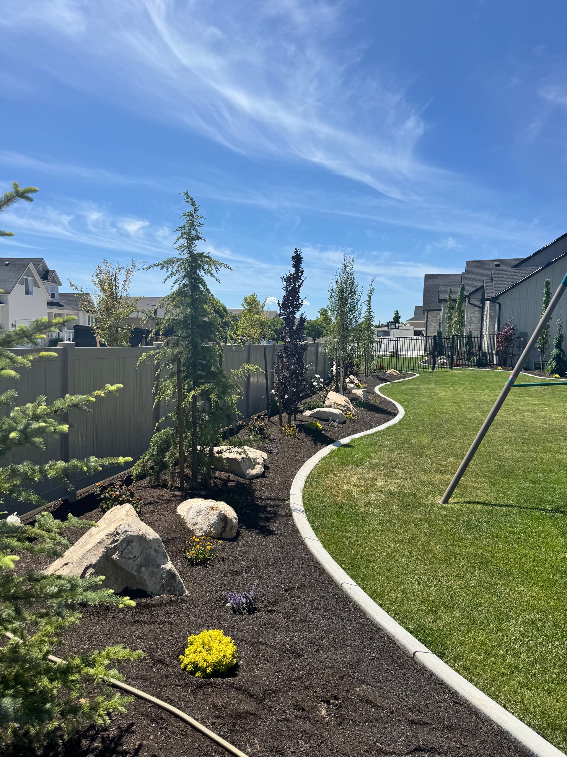 Backyard Plant Installation with Trees, Boulders, and Black Mulch in Lehi image