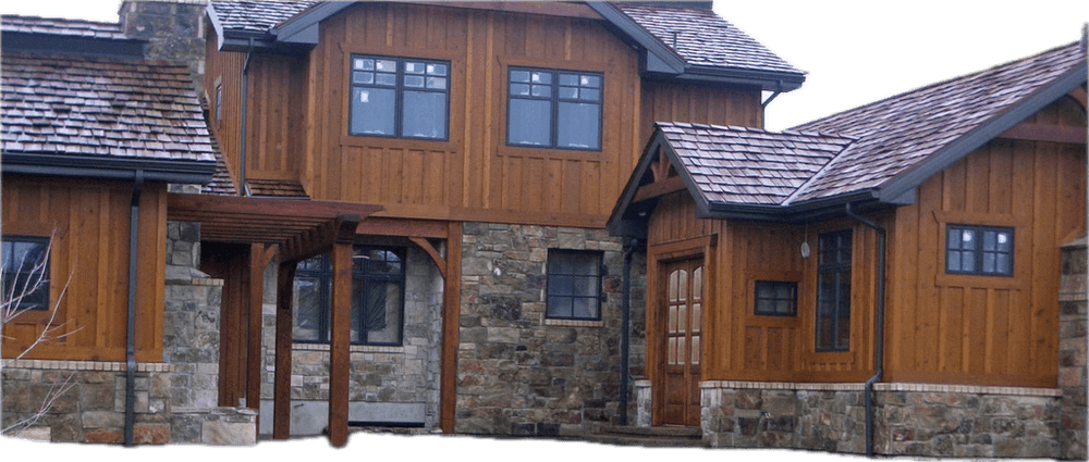 Rustic wooden house with stone accents and a gabled roof in a residential setting.